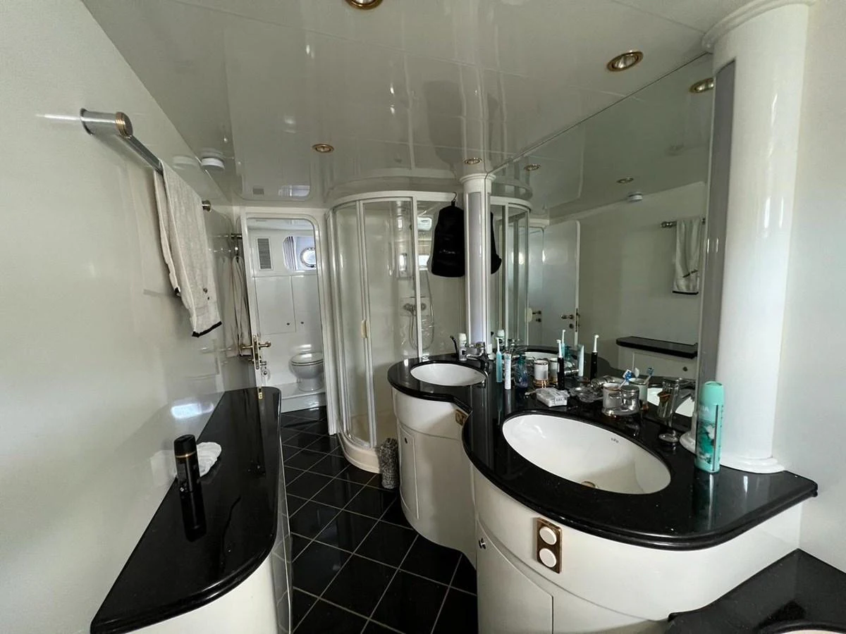 The yacht's bathroom features a sleek design with dual sinks and a spacious shower area. aboard HORIZON ELEGANCE 82 S Yacht for Sale