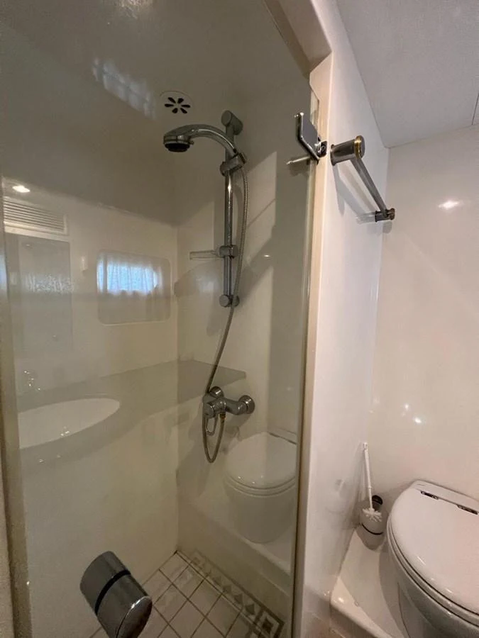 The yacht's bathroom features a modern shower and toilet setup. aboard HORIZON ELEGANCE 82 S Yacht for Sale