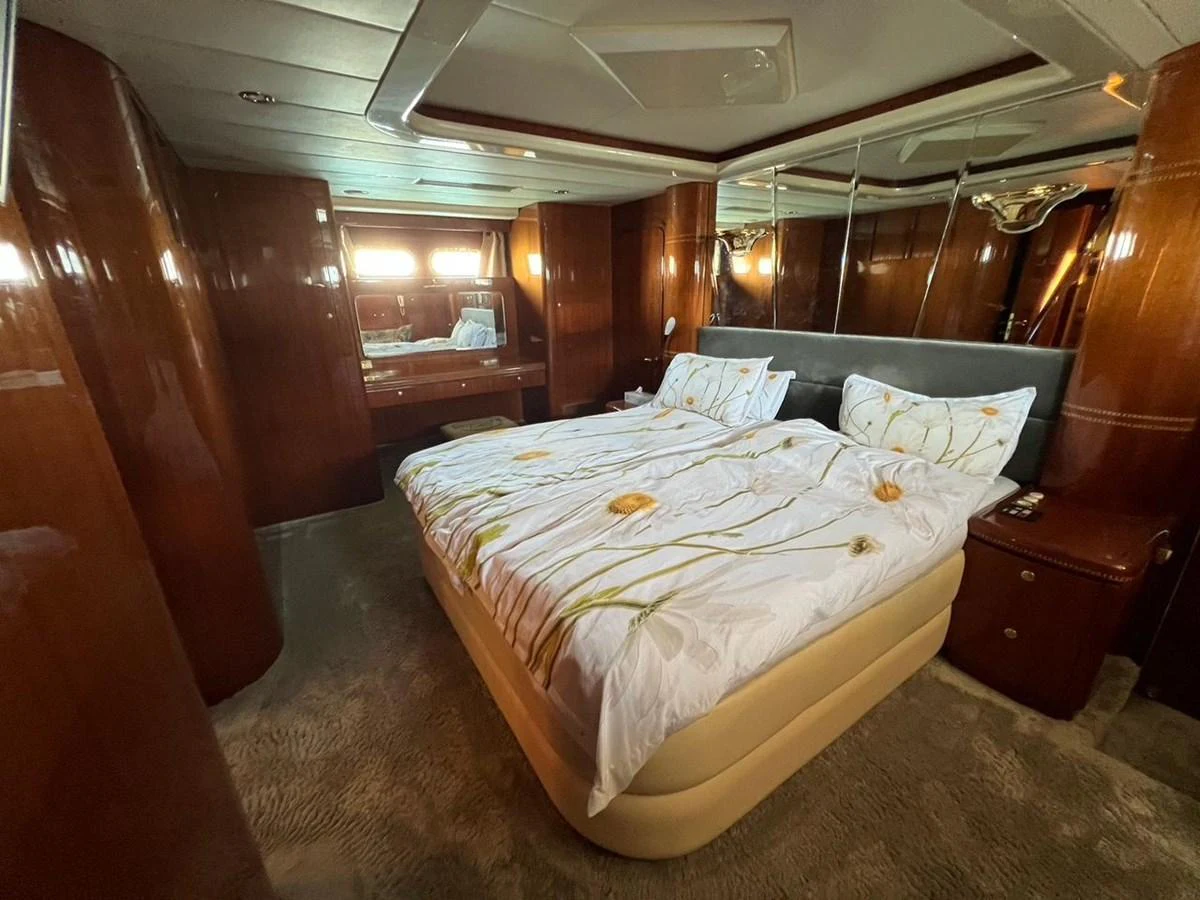 The master stateroom features a luxurious bed with elegant bedding and rich wood paneling. aboard HORIZON ELEGANCE 82 S Yacht for Sale