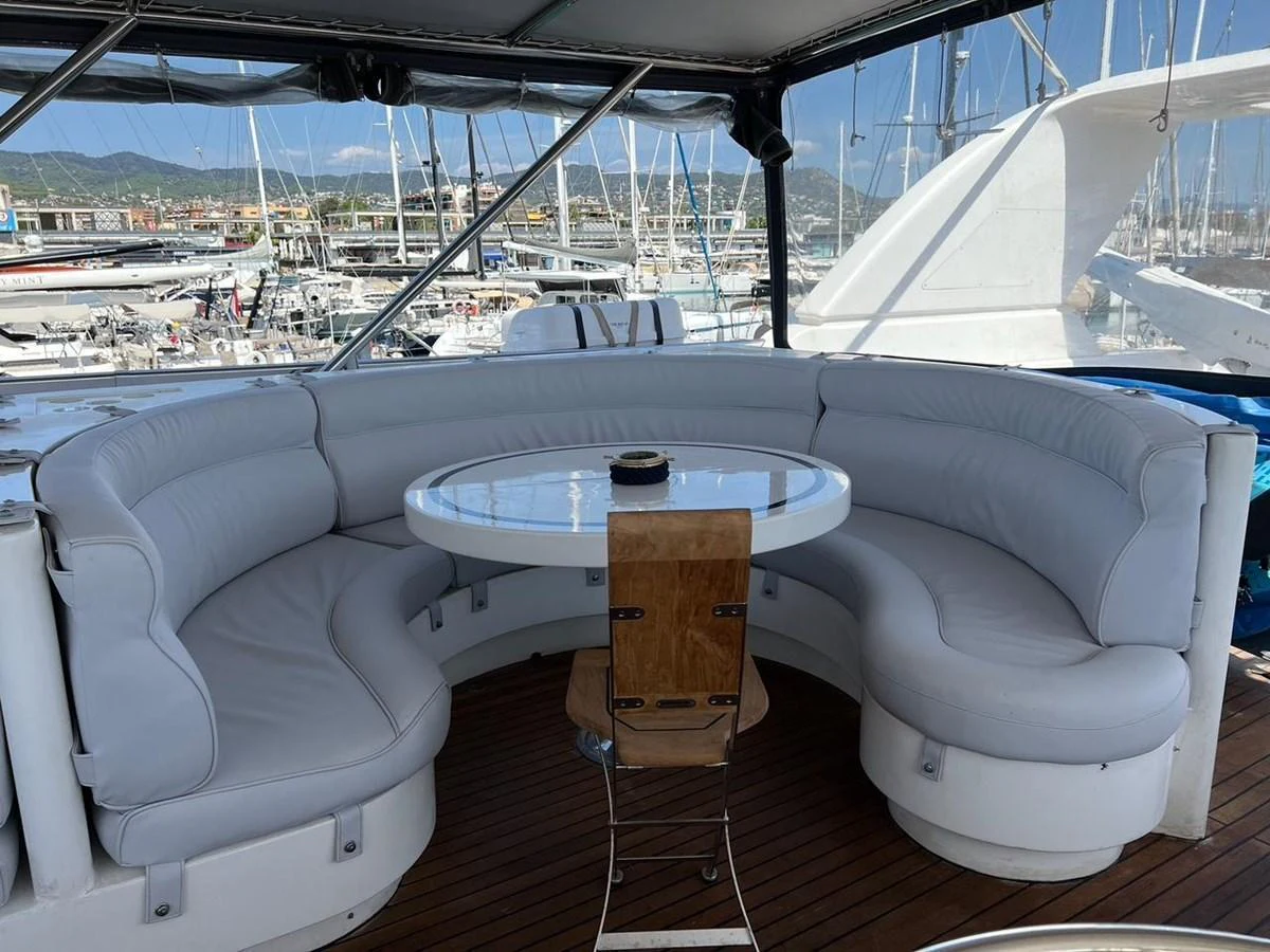 The flybridge features a comfortable circular seating area with a central table, perfect for socializing and enjoying the view. aboard HORIZON ELEGANCE 82 S Yacht for Sale