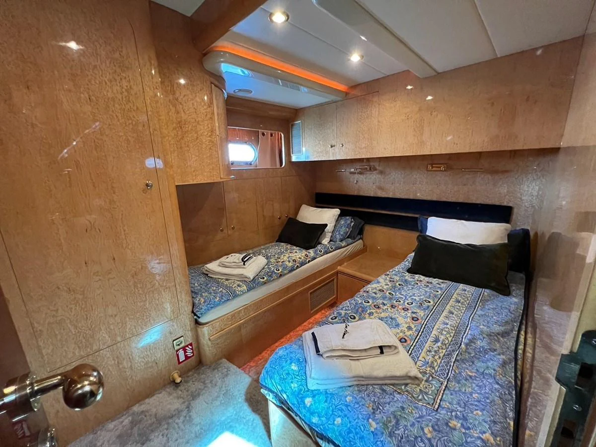 The twin stateroom features two single beds with elegant bedding and ample storage space. aboard HORIZON ELEGANCE 82 S Yacht for Sale