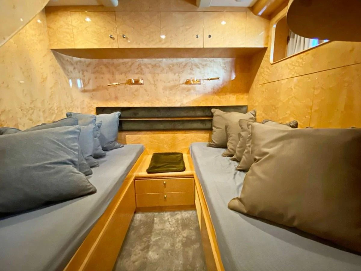 The guest cabin features cozy twin beds with plush pillows and warm wood finishes. aboard HORIZON ELEGANCE 82 S Yacht for Sale