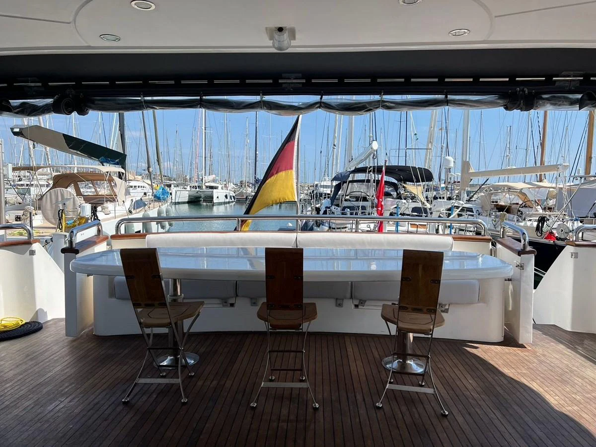 The aft deck features a spacious seating area with a sleek bar counter and comfortable chairs, perfect for enjoying marina views. aboard HORIZON ELEGANCE 82 S Yacht for Sale