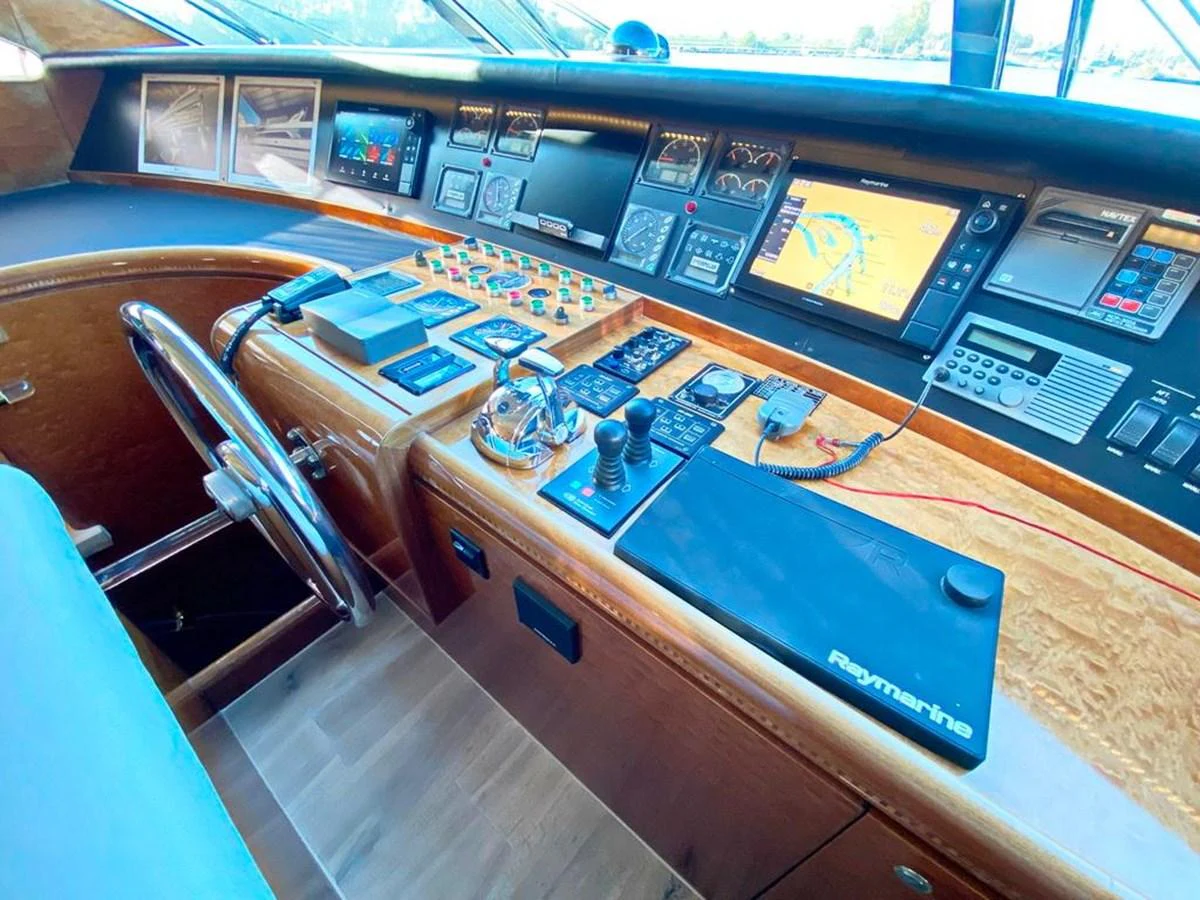 The helm station features advanced navigation and control systems with a luxurious wood finish. aboard HORIZON ELEGANCE 82 S Yacht for Sale