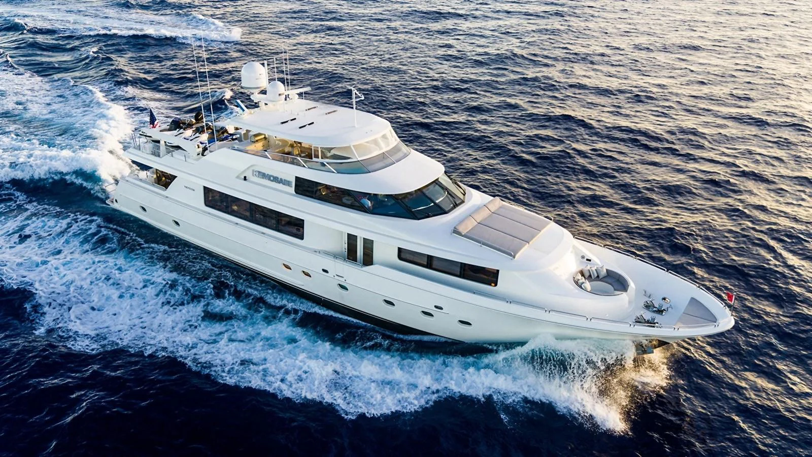 A luxurious yacht cruises gracefully through the open sea, showcasing its sleek design and spacious decks. aboard KEMOSABE Yacht for Sale