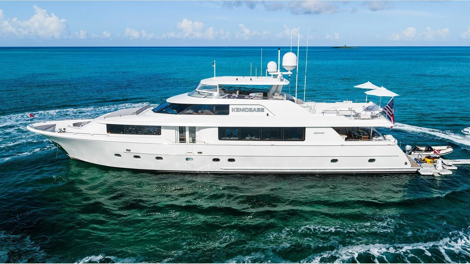 A sleek and modern yacht cruising on clear blue waters under a bright sky. aboard KEMOSABE Yacht for Sale
