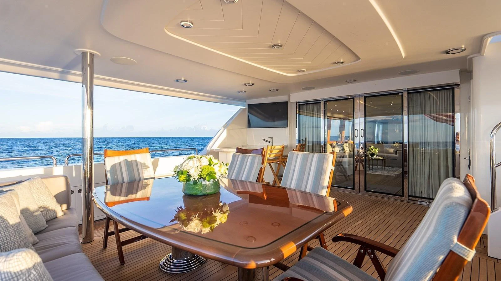 The aft deck features a spacious dining area with comfortable seating and a stunning ocean view. aboard KEMOSABE Yacht for Sale