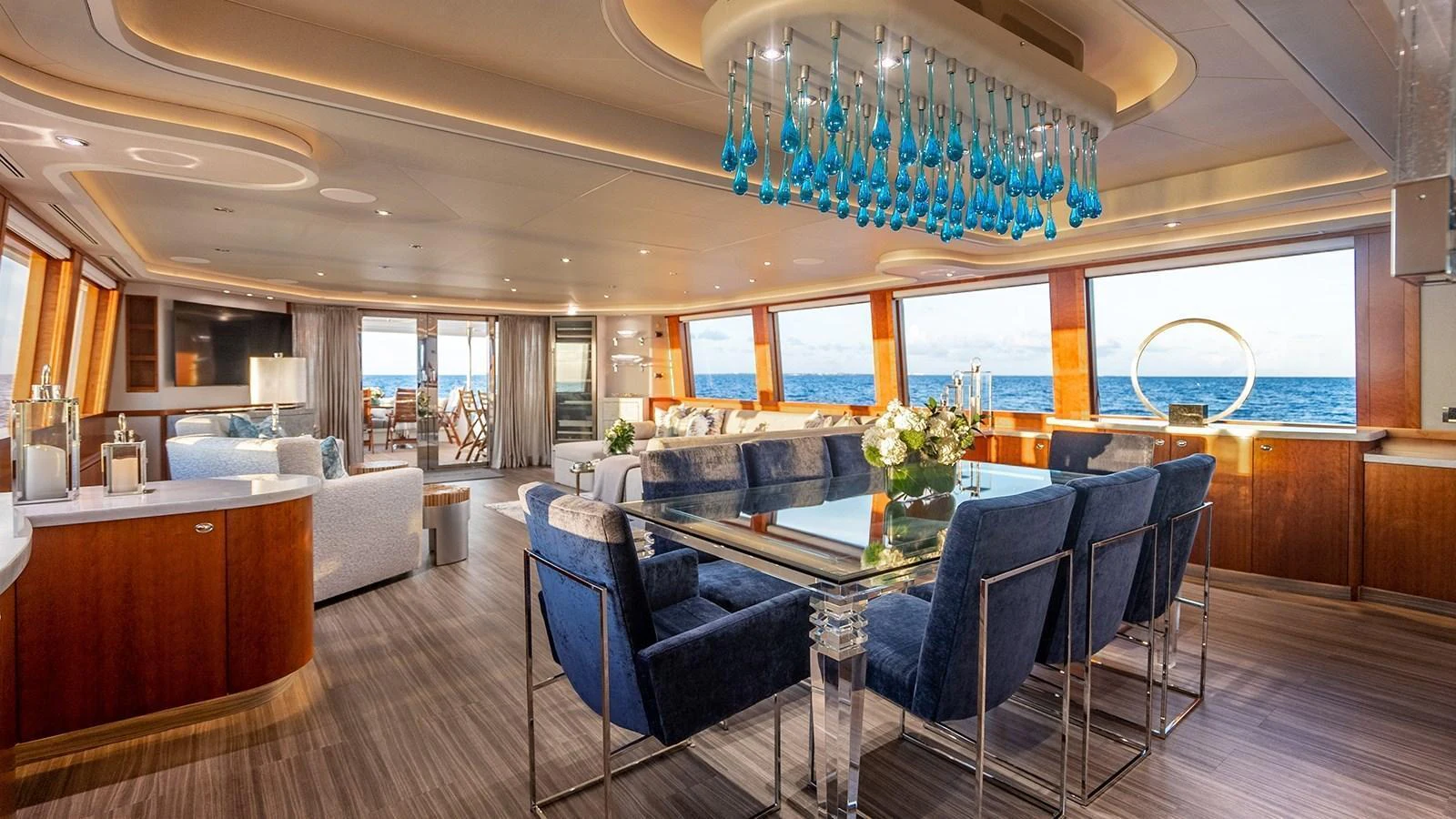 The salon features elegant furnishings, large windows, and a sophisticated chandelier, offering a luxurious and comfortable space for relaxation. aboard KEMOSABE Yacht for Sale