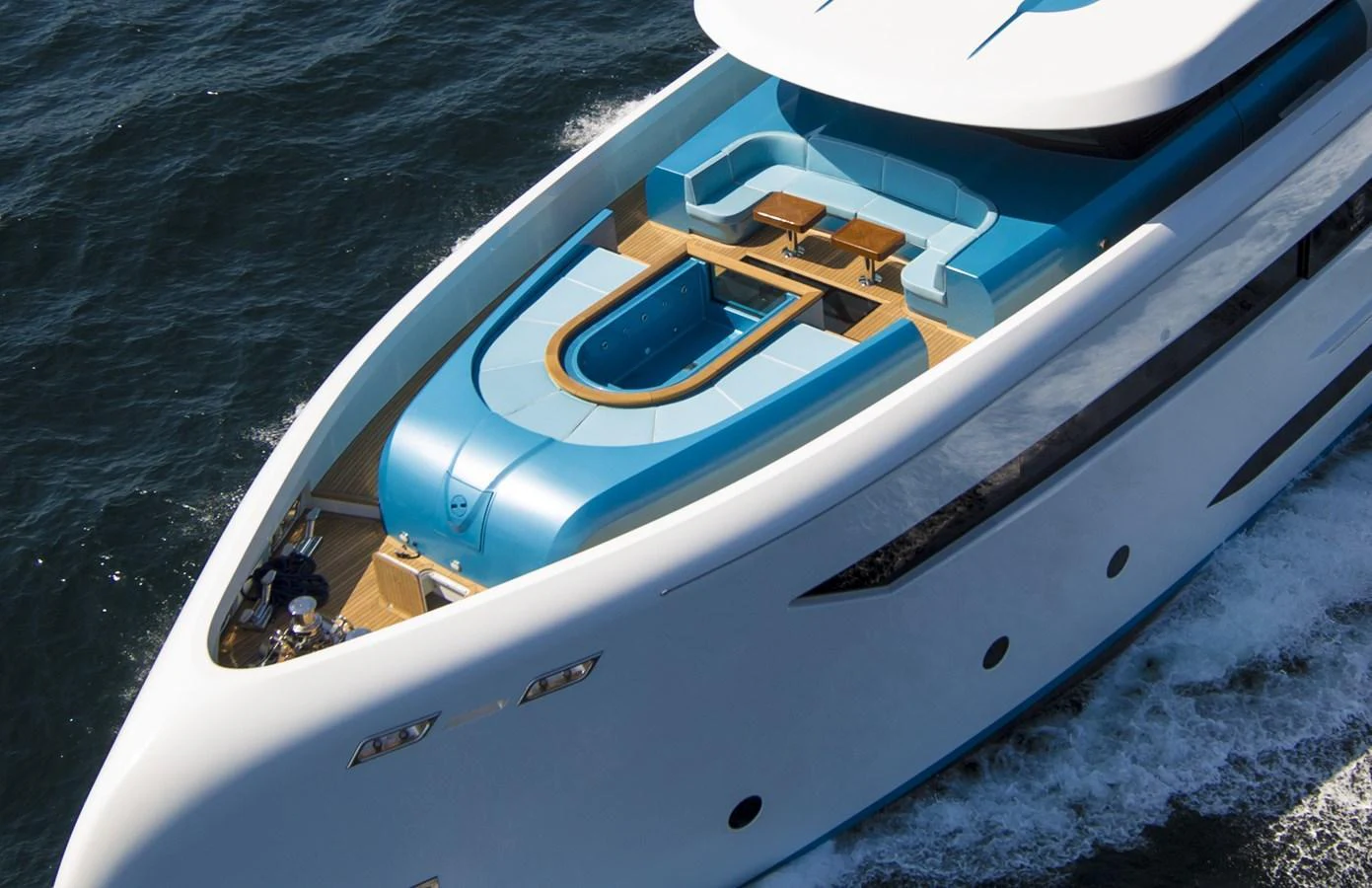 A sleek yacht with a luxurious sundeck featuring a pool and lounging area, cruising on the open water. aboard ELADA Yacht for Sale