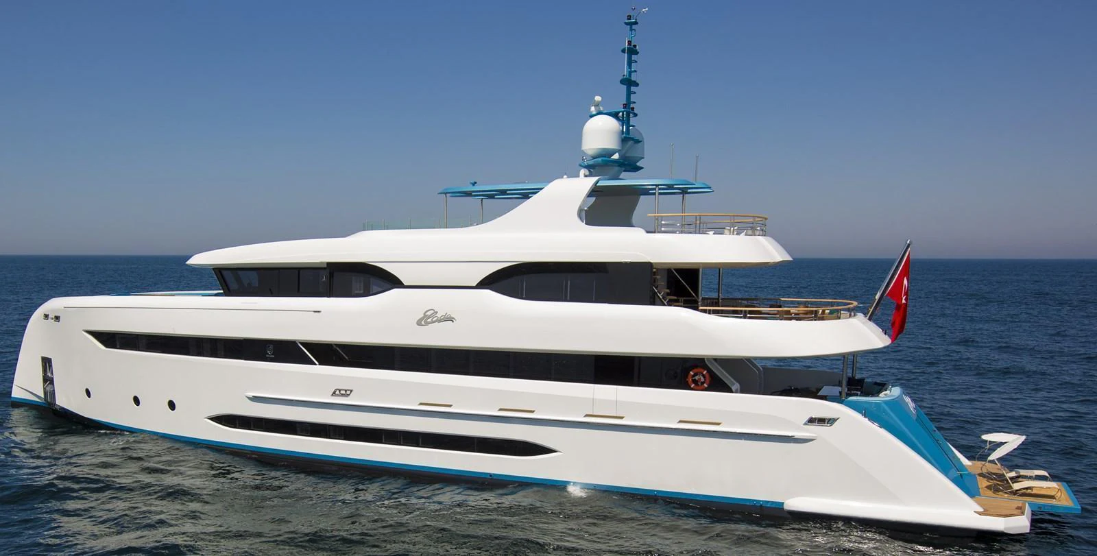 A sleek and modern yacht cruising on calm waters under a clear blue sky. aboard ELADA Yacht for Sale