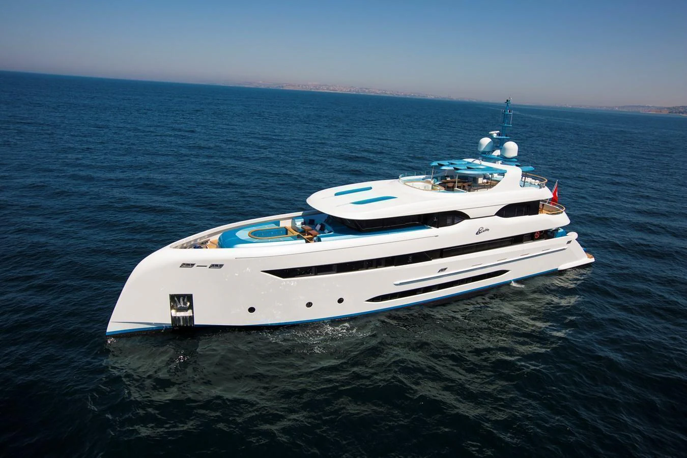 A sleek and modern yacht cruising on the open sea under a clear sky. aboard ELADA Yacht for Sale