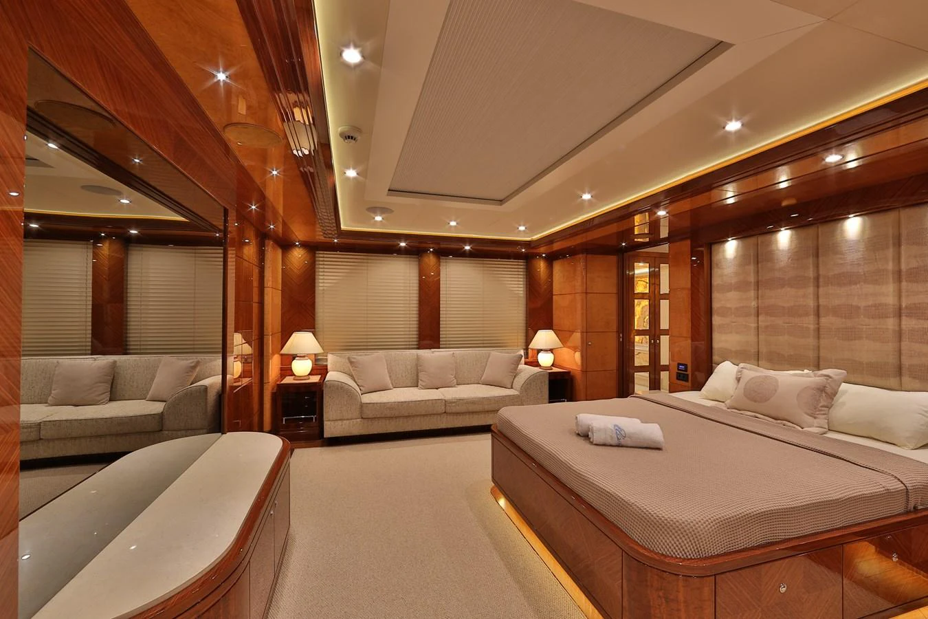 The master stateroom features luxurious wood paneling, a spacious bed, and a comfortable seating area. aboard ELADA Yacht for Sale