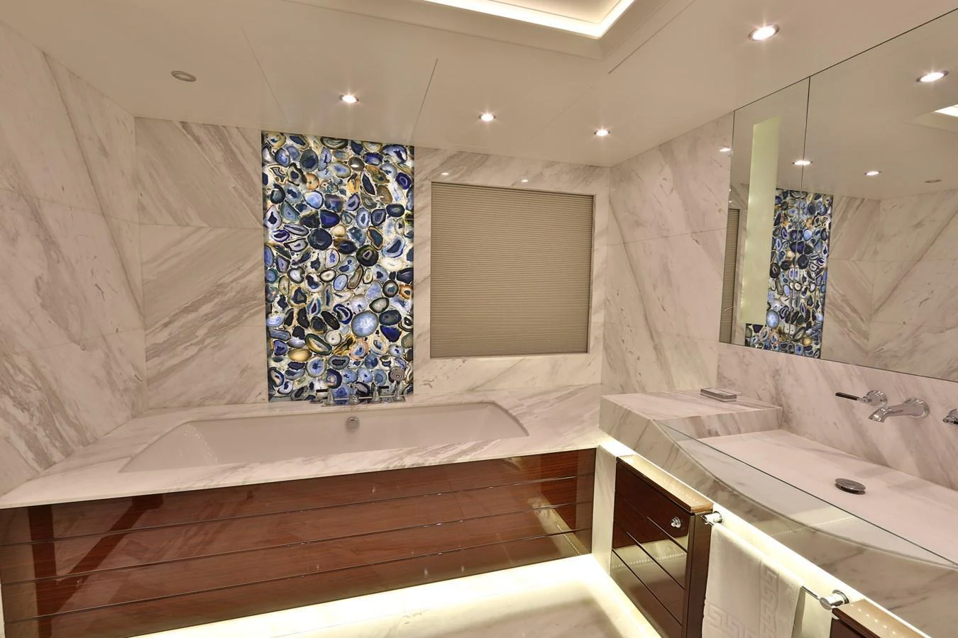 The luxurious bathroom features a marble bathtub and a stylish sink area with modern fixtures. aboard ELADA Yacht for Sale