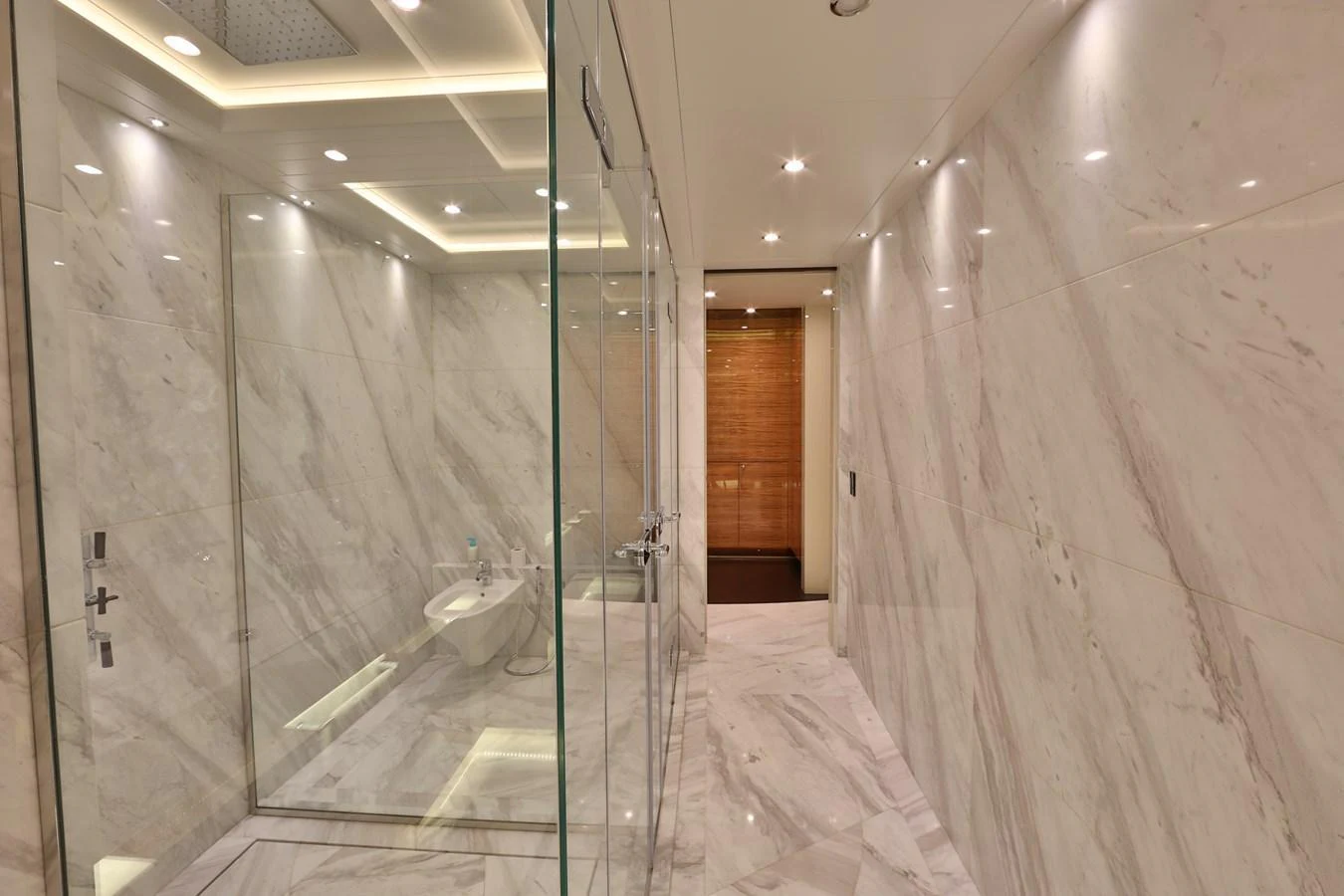 The yacht's bathroom features luxurious marble walls and modern fixtures. aboard ELADA Yacht for Sale