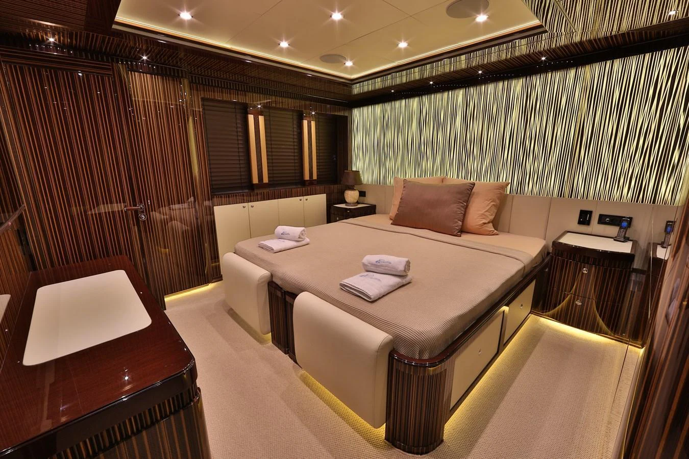 The master stateroom exudes luxury with its elegant wood paneling and ambient lighting. aboard ELADA Yacht for Sale