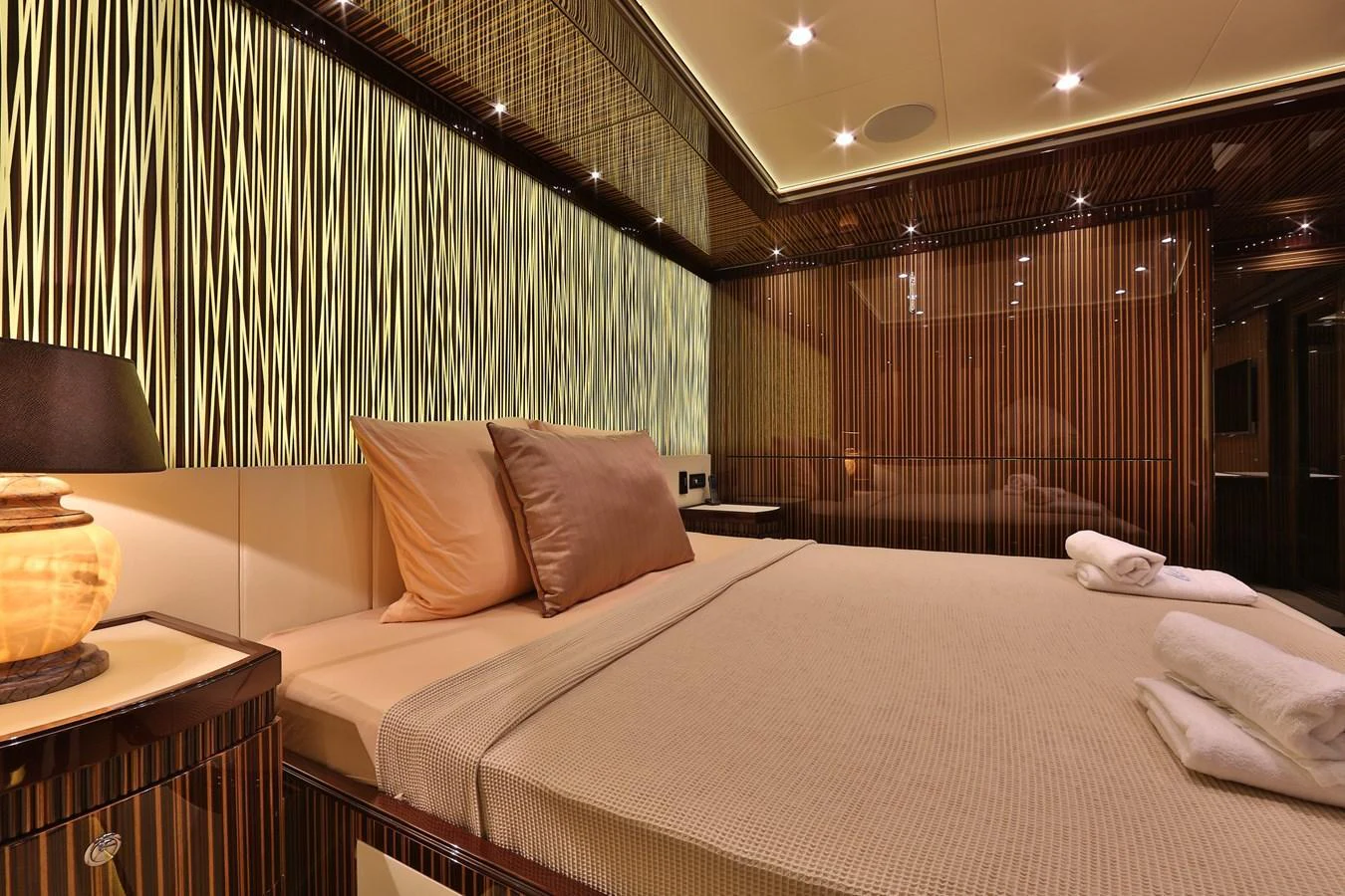 The stateroom features elegant wood paneling and luxurious bedding, creating a warm and inviting atmosphere. aboard ELADA Yacht for Sale