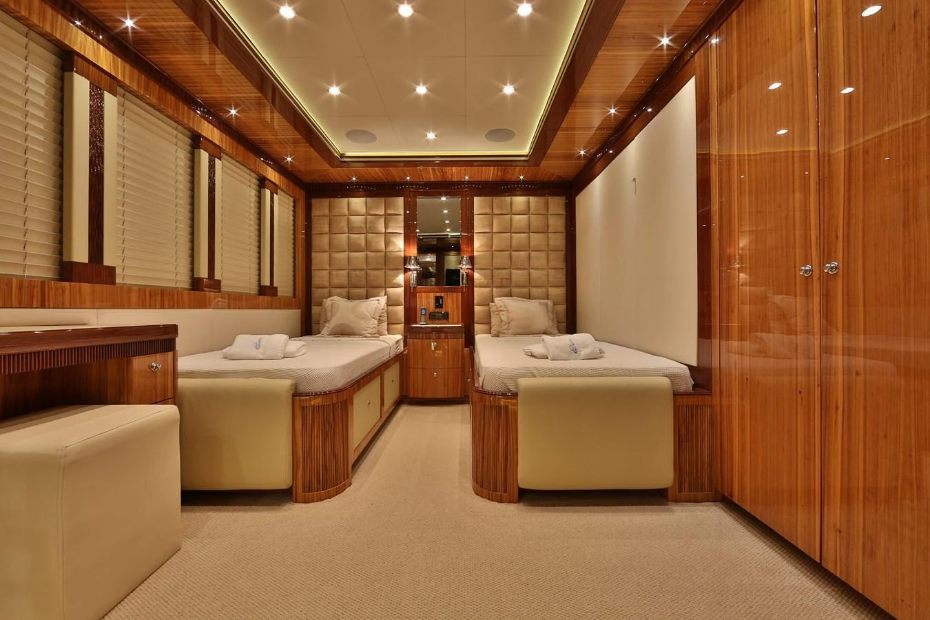 The guest stateroom features twin beds with luxurious wood paneling and ambient lighting. aboard ELADA Yacht for Sale