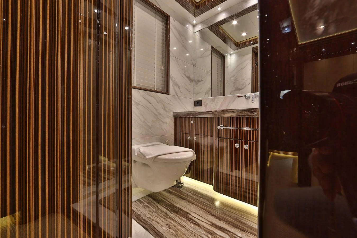 The yacht's bathroom features luxurious wood paneling and marble accents. aboard ELADA Yacht for Sale
