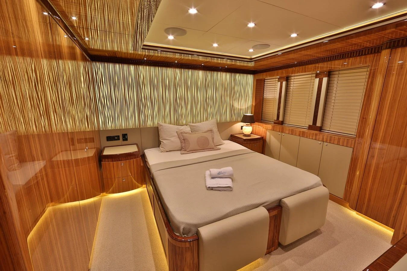 The master stateroom features luxurious wood paneling and ambient lighting, creating a warm and inviting atmosphere. aboard ELADA Yacht for Sale