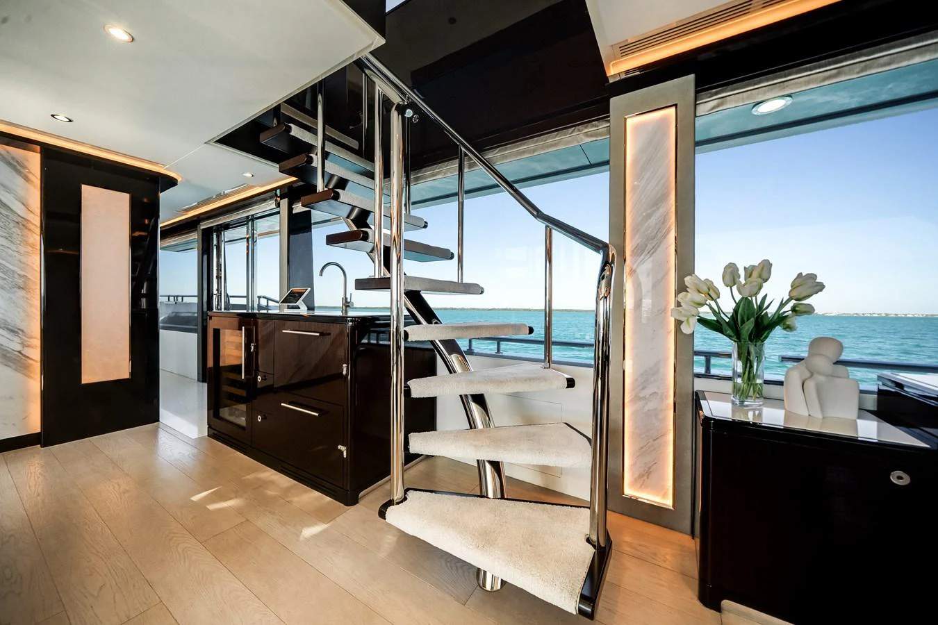 A modern yacht interior featuring a sleek spiral staircase with ocean views. aboard OCEAN ALEXANDER 37L/01 Yacht for Sale