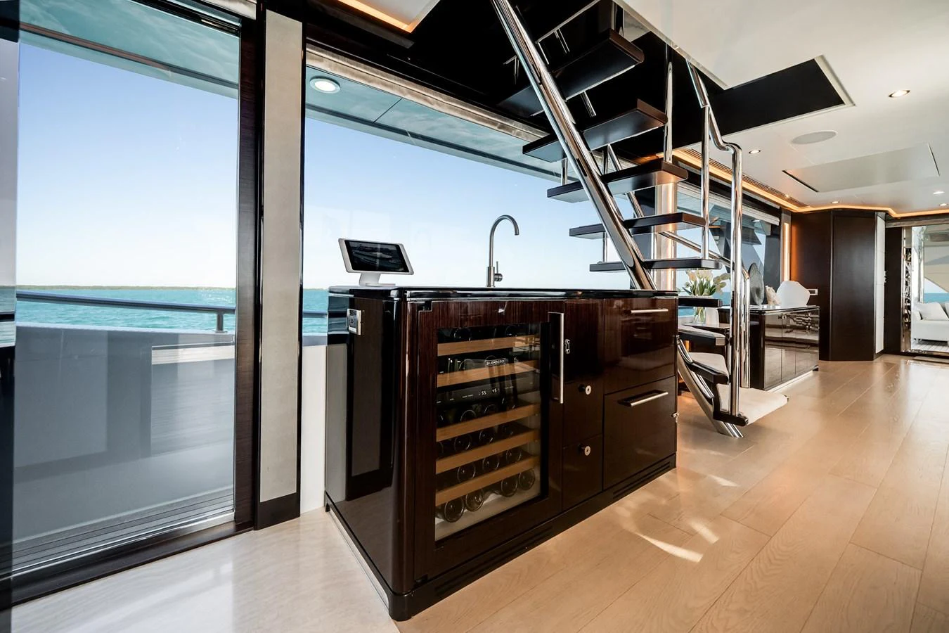 The modern galley features sleek cabinetry, a wine cooler, and a stylish staircase leading to the upper deck. aboard OCEAN ALEXANDER 37L/01 Yacht for Sale