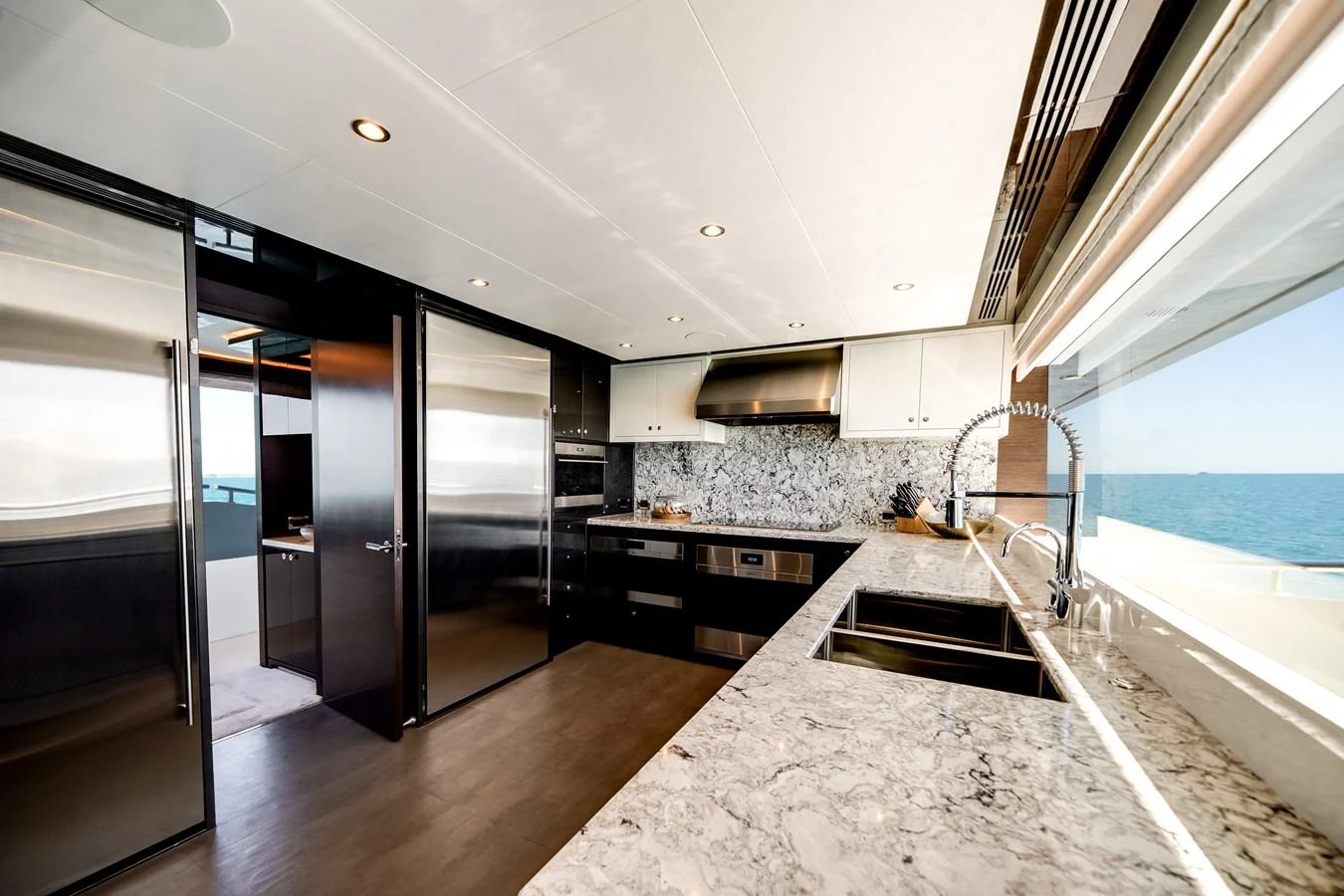 The galley features modern appliances and a sleek marble countertop with expansive ocean views. aboard OCEAN ALEXANDER 37L/01 Yacht for Sale