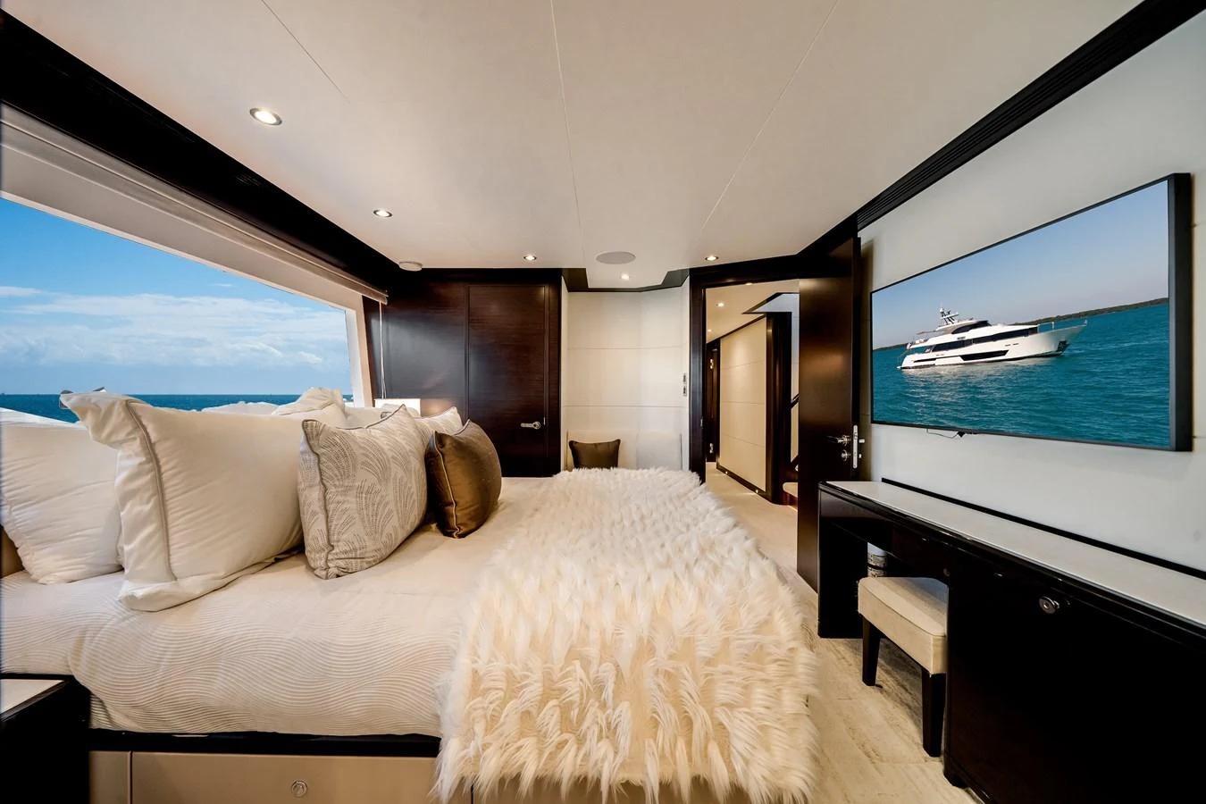 The luxurious stateroom features a large bed, plush bedding, and a scenic ocean view through the window. aboard OCEAN ALEXANDER 37L/01 Yacht for Sale
