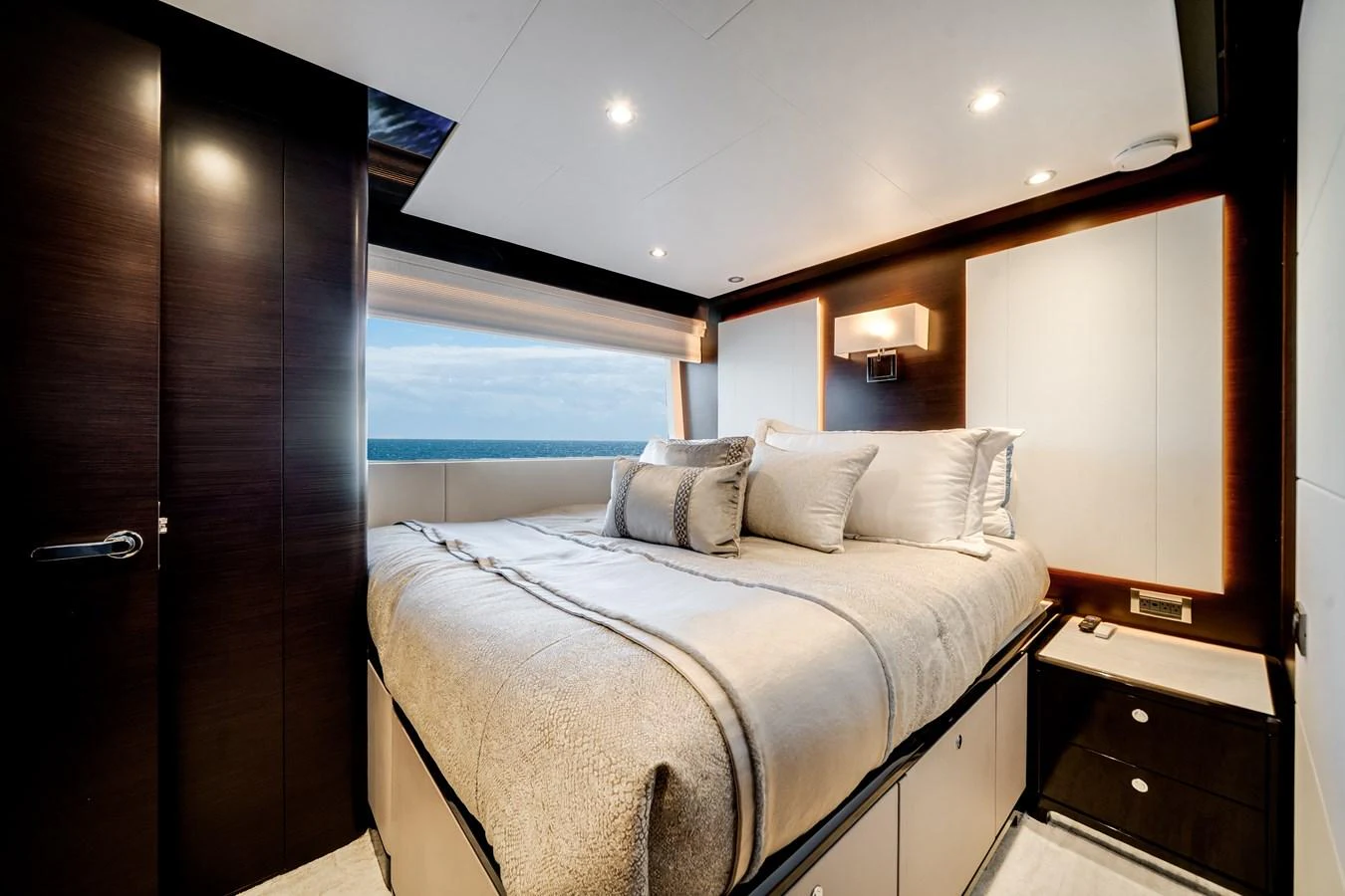 The stateroom features a luxurious bed with elegant bedding and a view of the sea through a large window. aboard OCEAN ALEXANDER 37L/01 Yacht for Sale