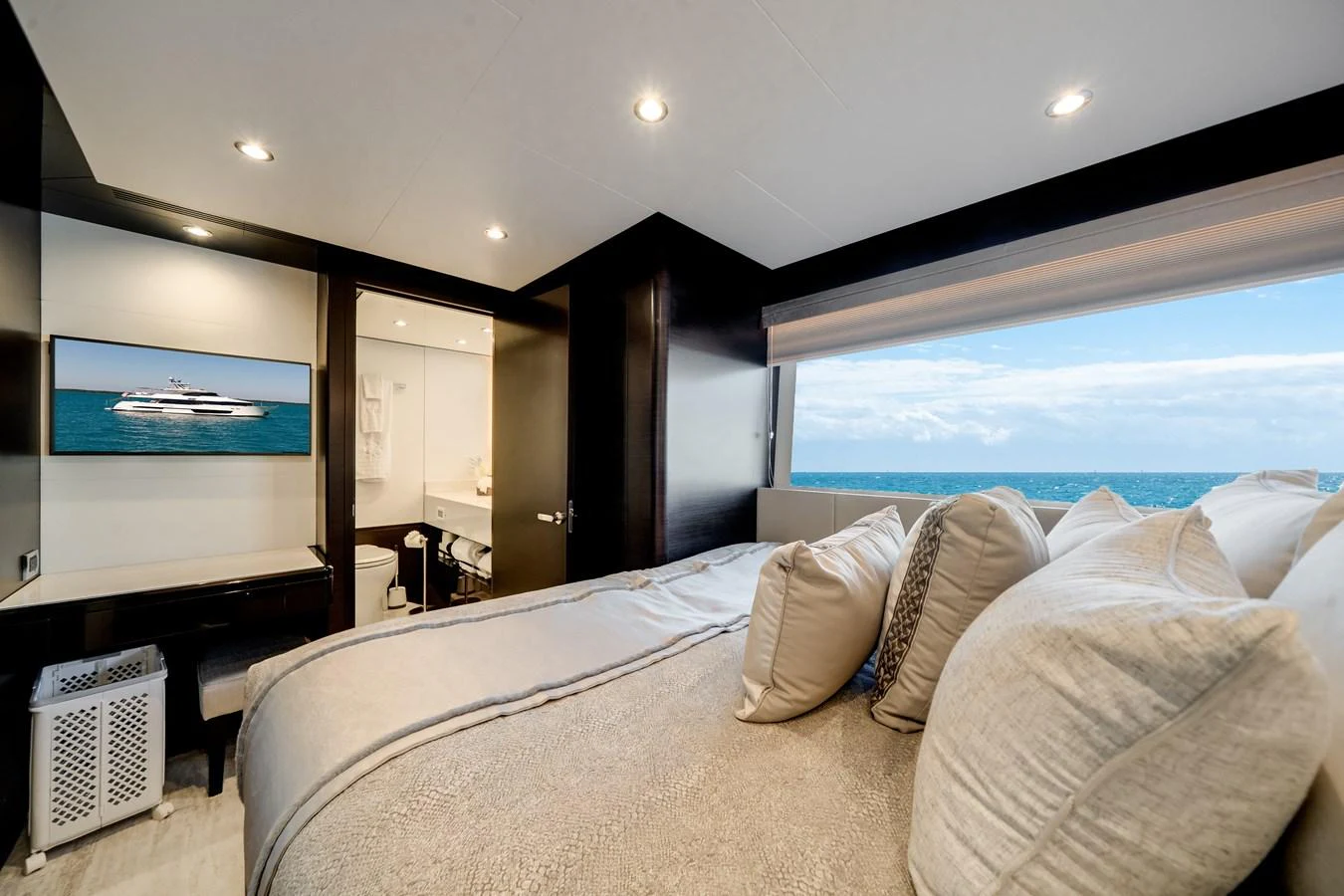 A luxurious stateroom with a large bed and an ocean view through a wide window. aboard OCEAN ALEXANDER 37L/01 Yacht for Sale