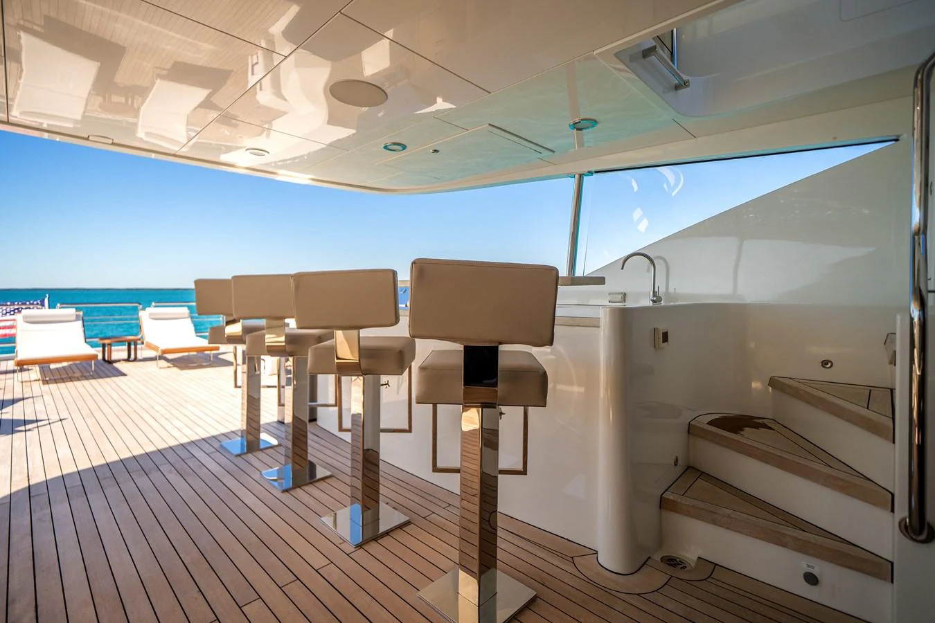 The aft deck features a stylish bar area with high stools and a view of the sea. aboard OCEAN ALEXANDER 37L/01 Yacht for Sale