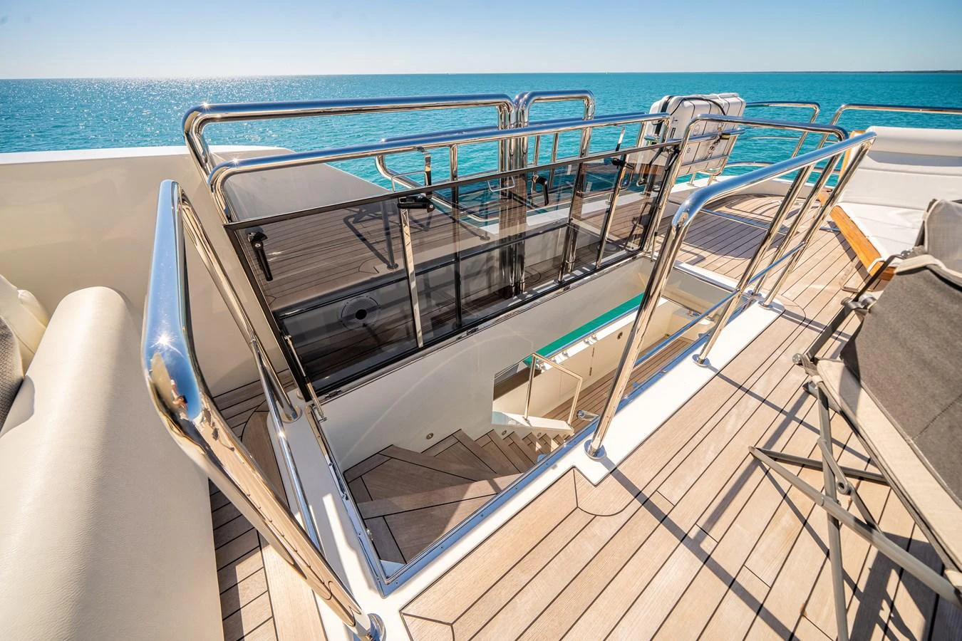 The sundeck offers a luxurious space with a staircase leading down to the lower deck, surrounded by gleaming stainless steel railings. aboard OCEAN ALEXANDER 37L/01 Yacht for Sale