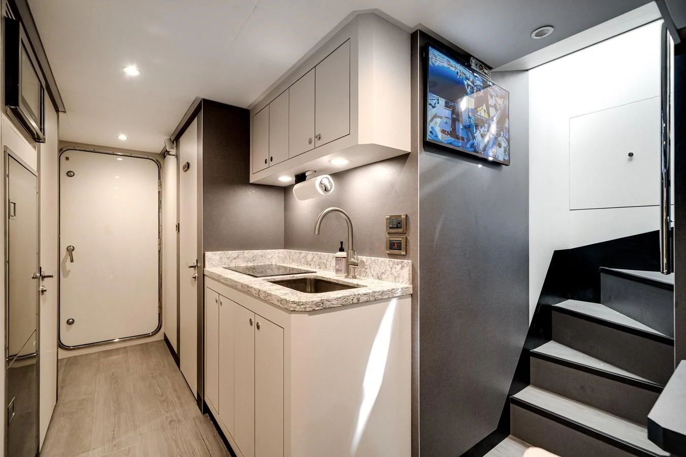 The yacht's galley features modern cabinetry, a sleek countertop, and a staircase leading to the upper deck. aboard OCEAN ALEXANDER 37L/01 Yacht for Sale