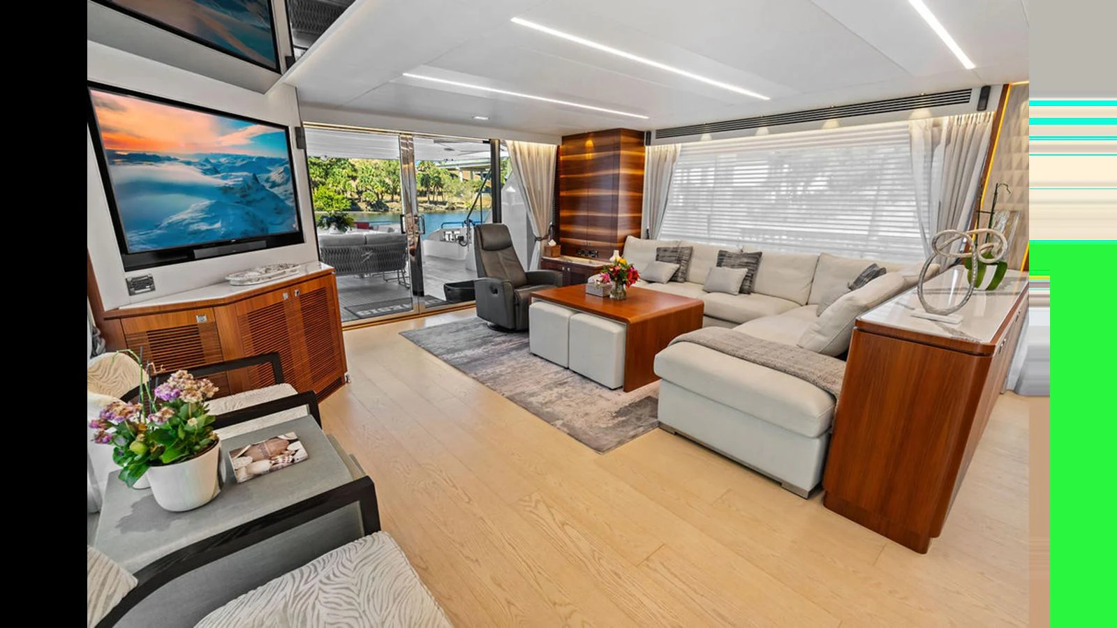 a living room with a large screen aboard MOBILLITY Yacht for Sale