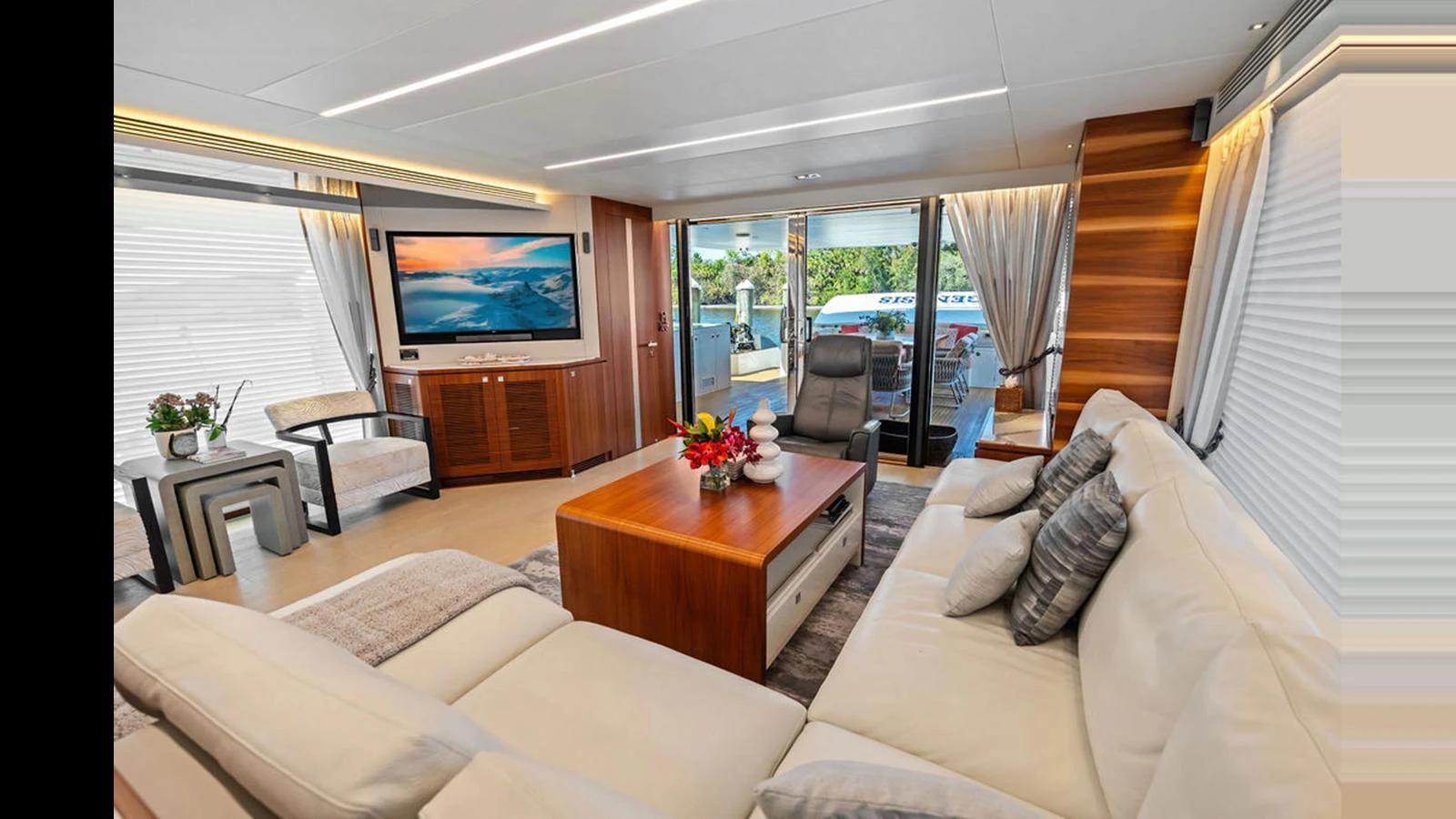 a living room with a tv and furniture aboard MOBILLITY Yacht for Sale