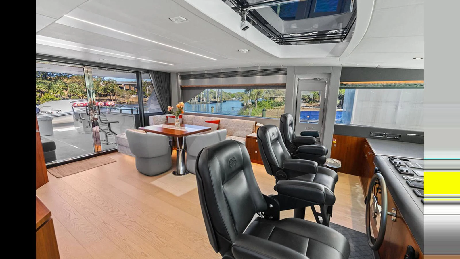 a room with a table chairs and a table with a window aboard MOBILLITY Yacht for Sale