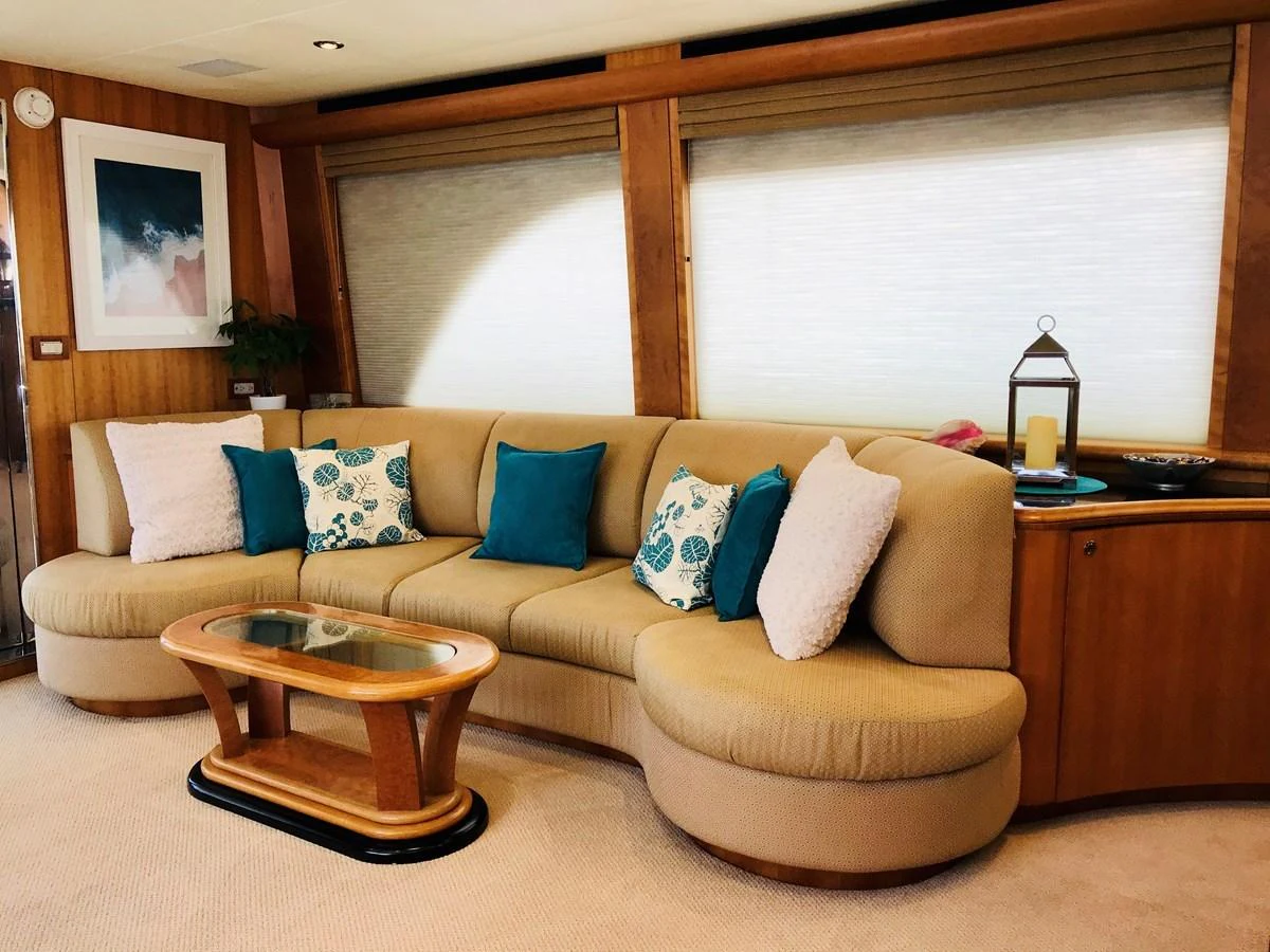 The salon features a comfortable curved sofa with colorful cushions and a stylish coffee table. aboard BREAKAWAY Yacht for Sale