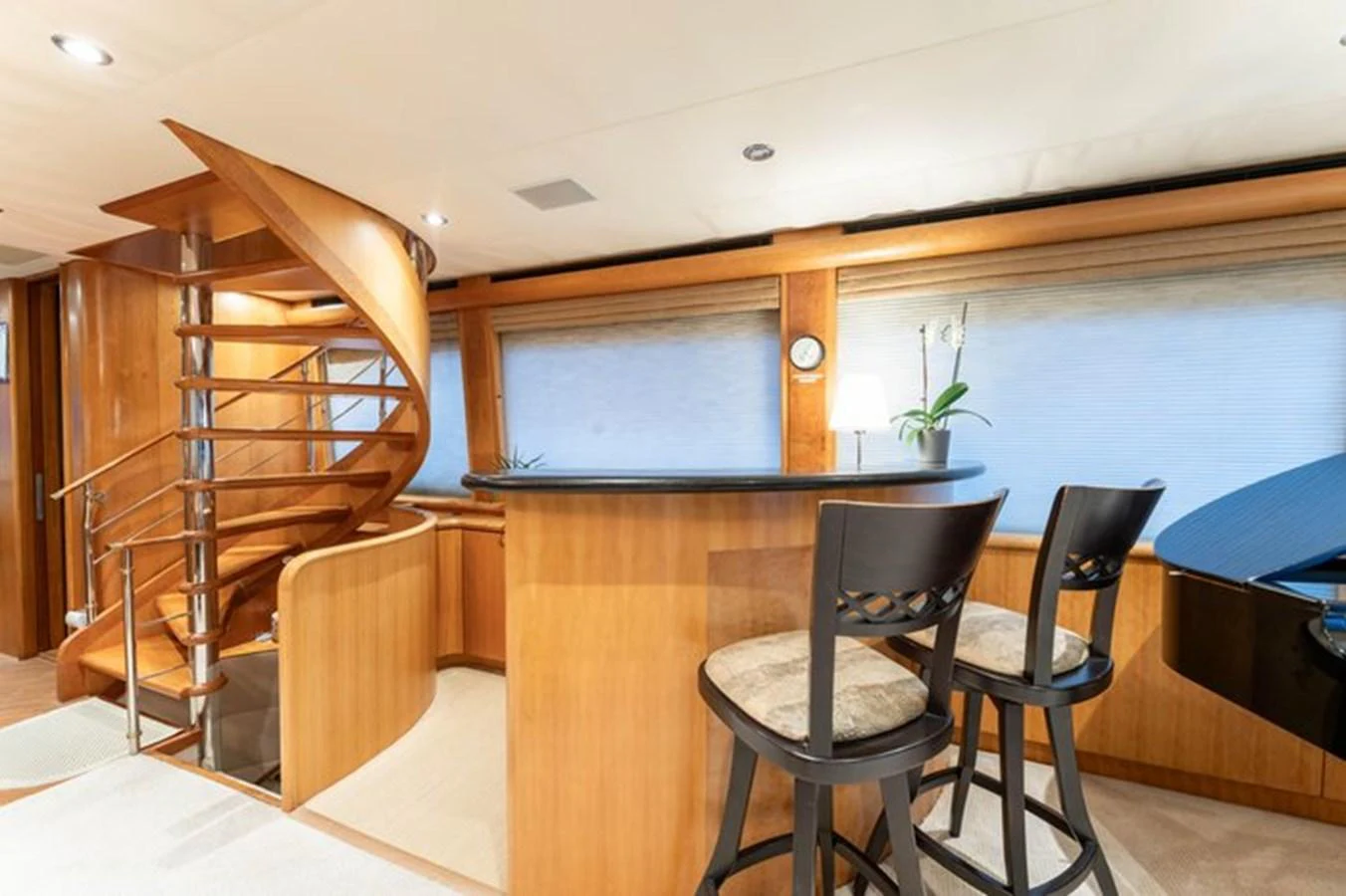 The salon features a stylish bar area with elegant seating and a spiral staircase leading to the upper deck. aboard BREAKAWAY Yacht for Sale