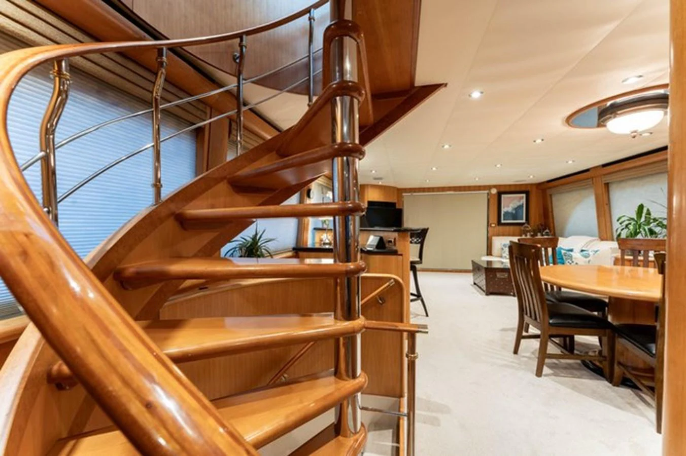 The yacht's salon features a beautifully crafted wooden staircase and a spacious dining area with elegant furnishings. aboard BREAKAWAY Yacht for Sale