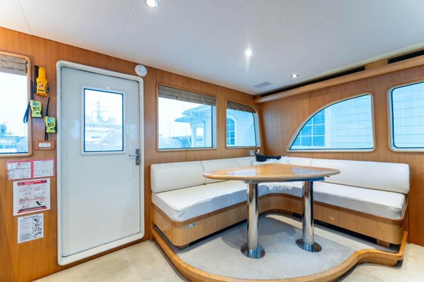 The yacht's saloon features a cozy seating area with a wooden table and large windows for natural light. aboard BREAKAWAY Yacht for Sale
