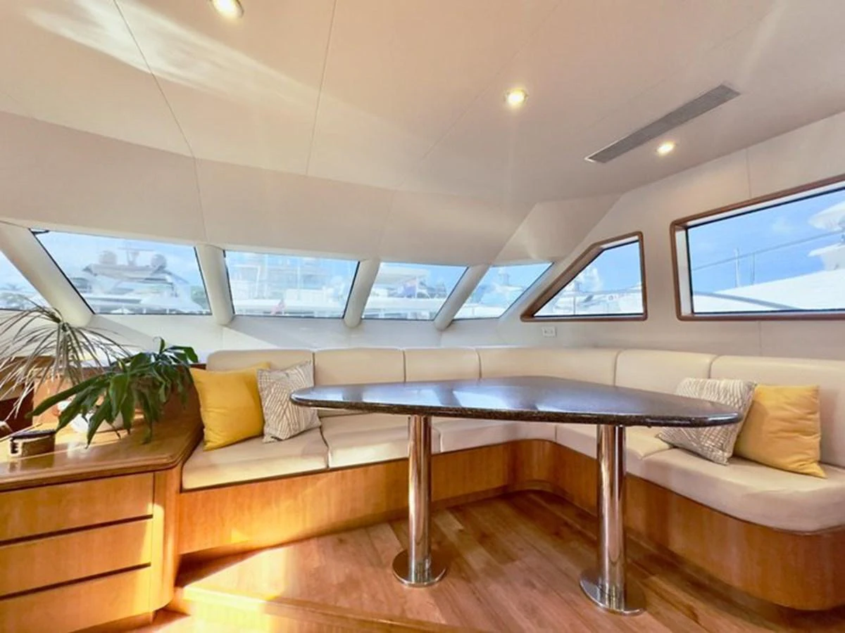 The saloon features a cozy seating area with large windows providing ample natural light. aboard BREAKAWAY Yacht for Sale