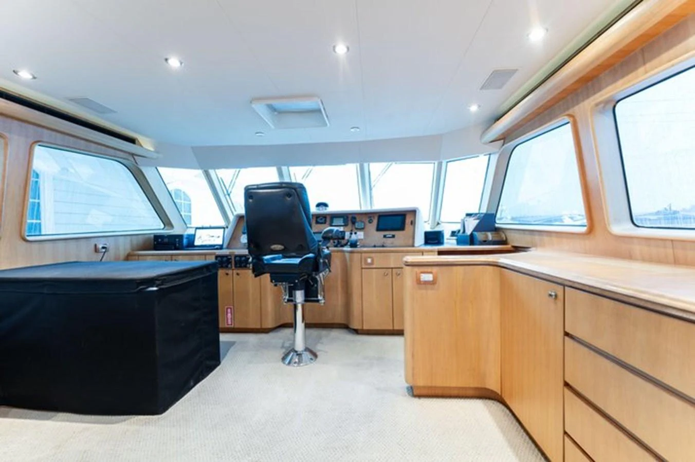 The helm station features modern navigation equipment and a comfortable captain's chair, surrounded by expansive windows for excellent visibility. aboard BREAKAWAY Yacht for Sale