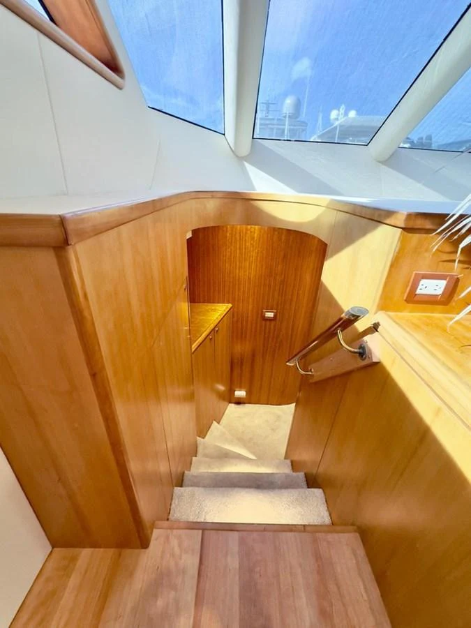 A well-lit interior stairway with wooden finishes and a skylight above. aboard BREAKAWAY Yacht for Sale