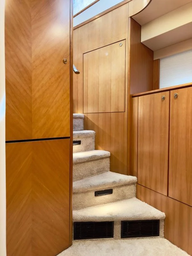 A cozy, carpeted staircase with wooden paneling leads to the upper level of the yacht. aboard BREAKAWAY Yacht for Sale