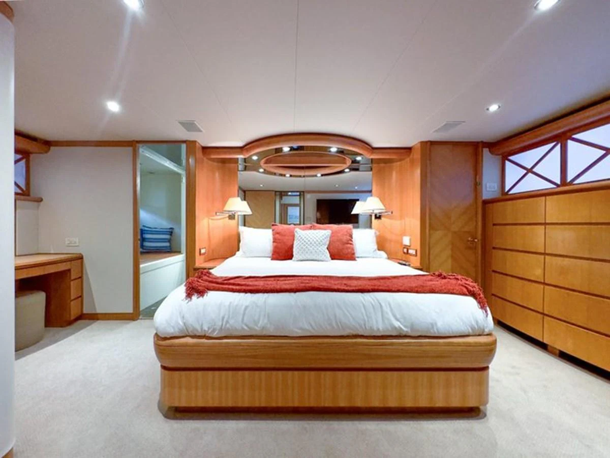 The master stateroom features a spacious bed with elegant wood finishes and modern lighting. aboard BREAKAWAY Yacht for Sale