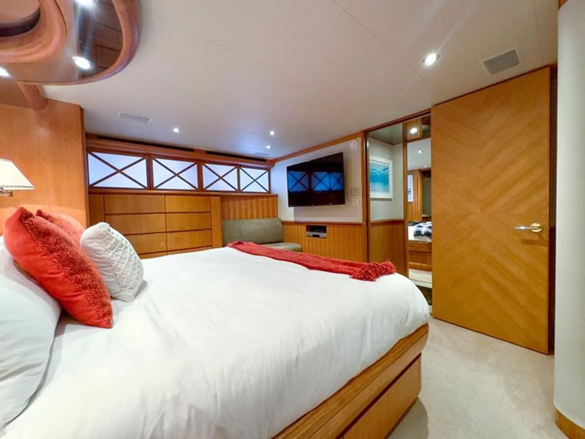 A cozy stateroom featuring a large bed with plush pillows and a flat-screen TV. aboard BREAKAWAY Yacht for Sale