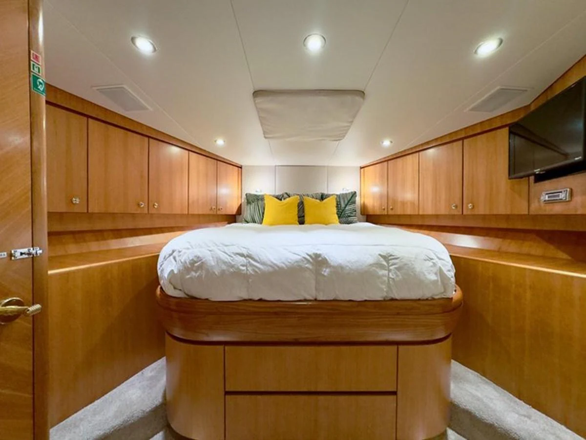 The stateroom features a cozy bed with ample storage and warm wood finishes. aboard BREAKAWAY Yacht for Sale