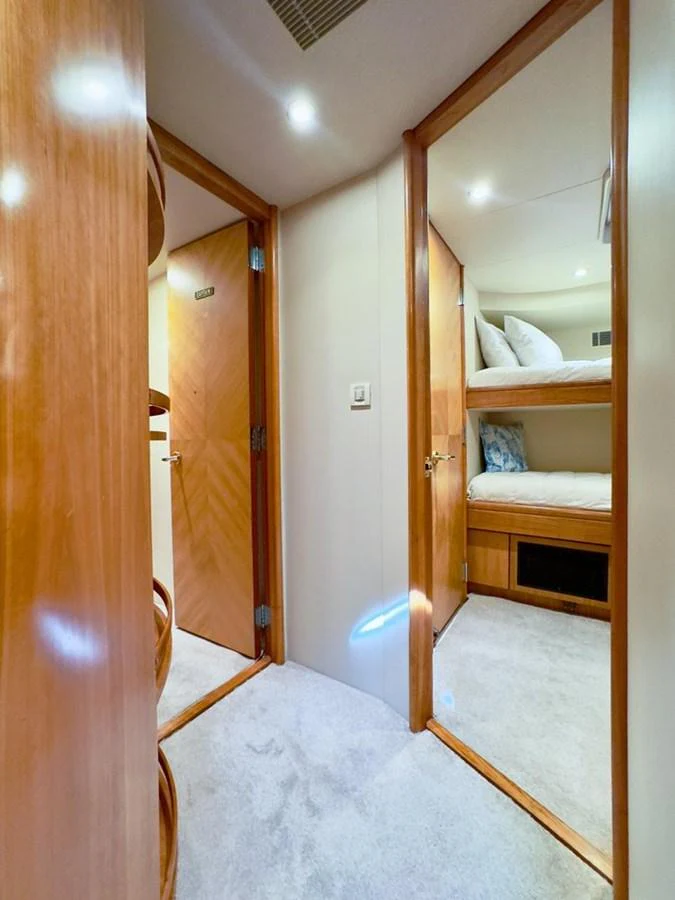 A cozy hallway leads to a cabin with bunk beds, showcasing the yacht's efficient use of space. aboard BREAKAWAY Yacht for Sale