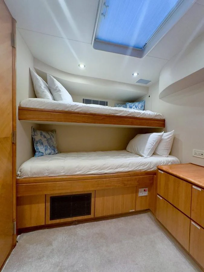 This cozy bunk room features two comfortable beds with plush pillows and a skylight for natural light. aboard BREAKAWAY Yacht for Sale