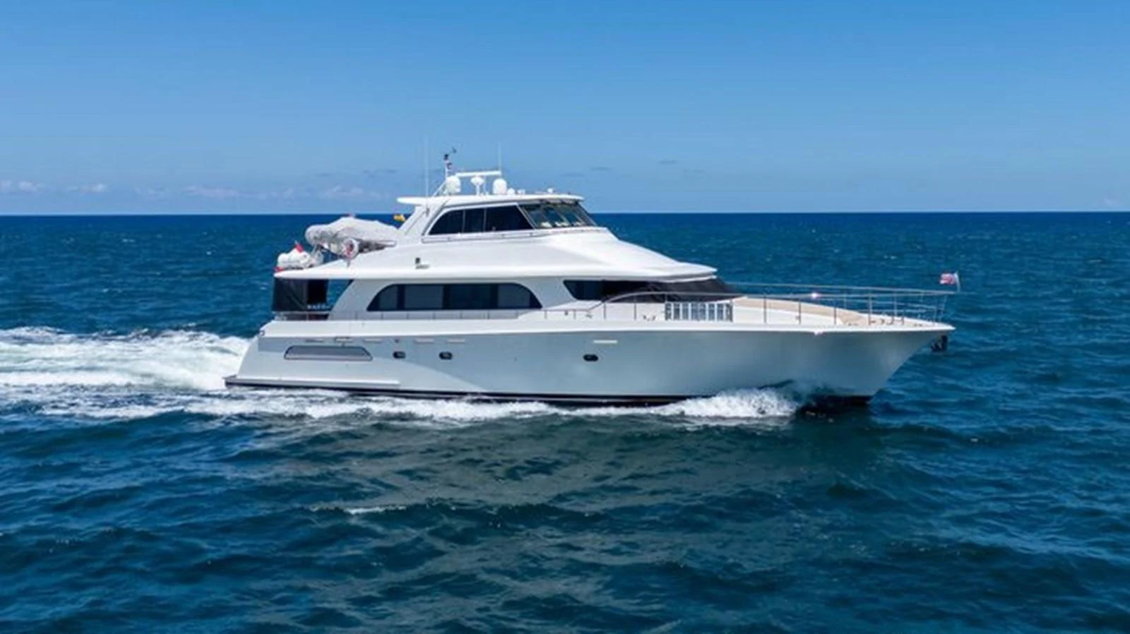 A sleek and modern yacht cruising on the open sea under a clear blue sky. aboard BREAKAWAY Yacht for Sale
