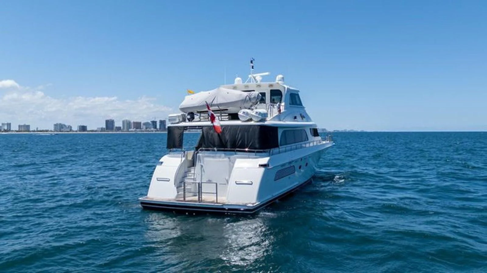 A luxurious yacht cruising on open waters with a clear skyline in the background. aboard BREAKAWAY Yacht for Sale